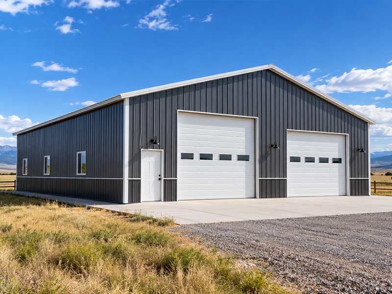 Charcoal steel workshop with two white overhead doors and a walk door
