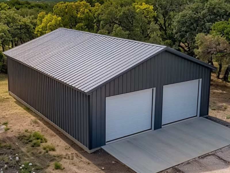 Aerial view of a charcoal metal garage with two white doors among trees