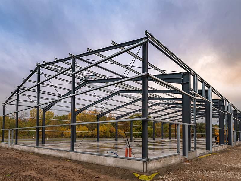 Bare steel building frame standing on a concrete foundation